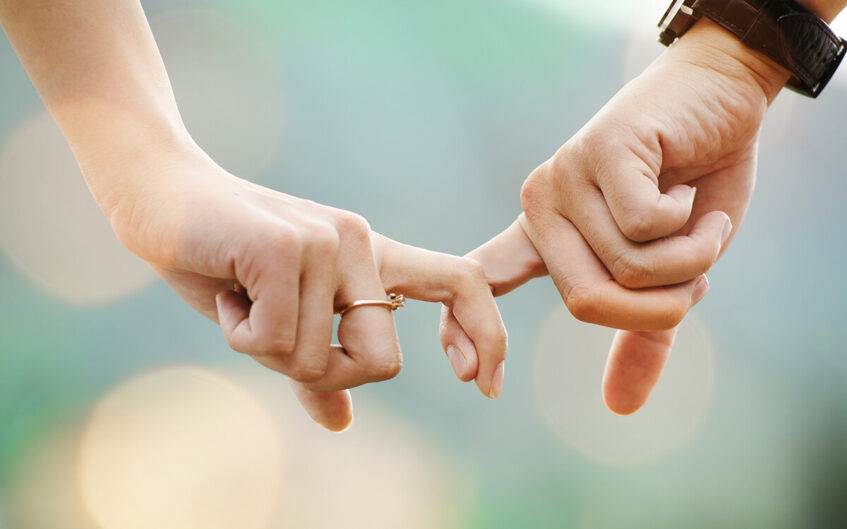 Maintaining respect in marriage. A couple holding each other by the finger.