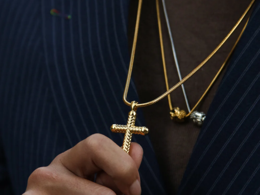 gold chains with a suit. A cross pendant hanging on a gold chain.