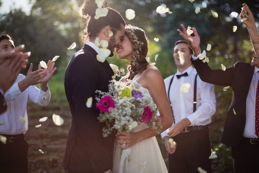 A couple on their wedding day, surrounded by family members.